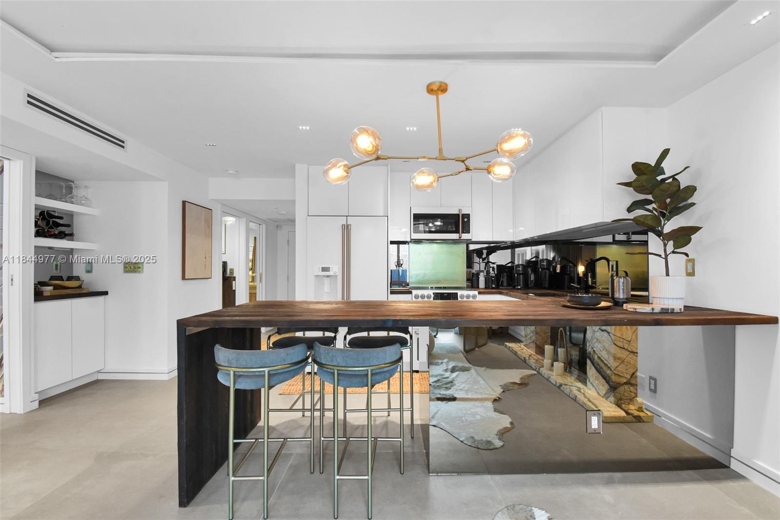 2301 Collins Avenue, Unit 1201 Miami Beach, FL 33139 - Photo 12 of 53 a kitchen with stainless steel appliances kitchen island granite countertop a table chairs sink and cabinets