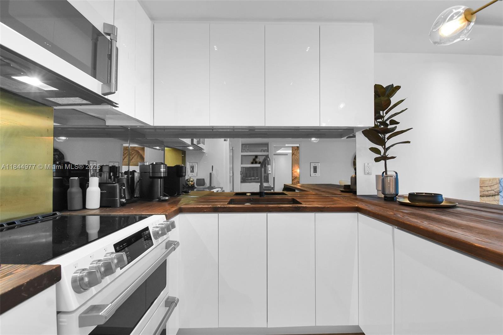 2301 Collins Avenue, Unit 1201 Miami Beach, FL 33139 - Photo 16 of 53 a kitchen with granite countertop a sink and a stove