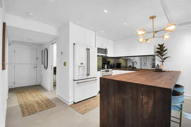 a kitchen with kitchen island stainless steel appliances a refrigerator sink and microwave