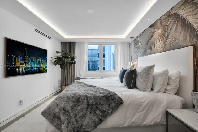 a bedroom with a large bed and a flat screen tv