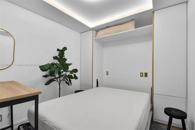 a bedroom with a bed and a potted plant