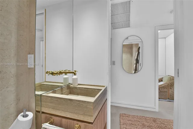 a bathroom with a granite countertop sink a toilet and a mirror