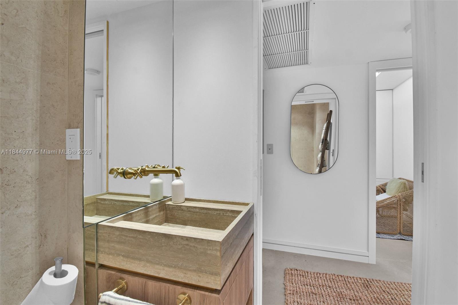 2301 Collins Avenue, Unit 1201 Miami Beach, FL 33139 - Photo 30 of 53 a bathroom with a granite countertop sink a toilet and a mirror