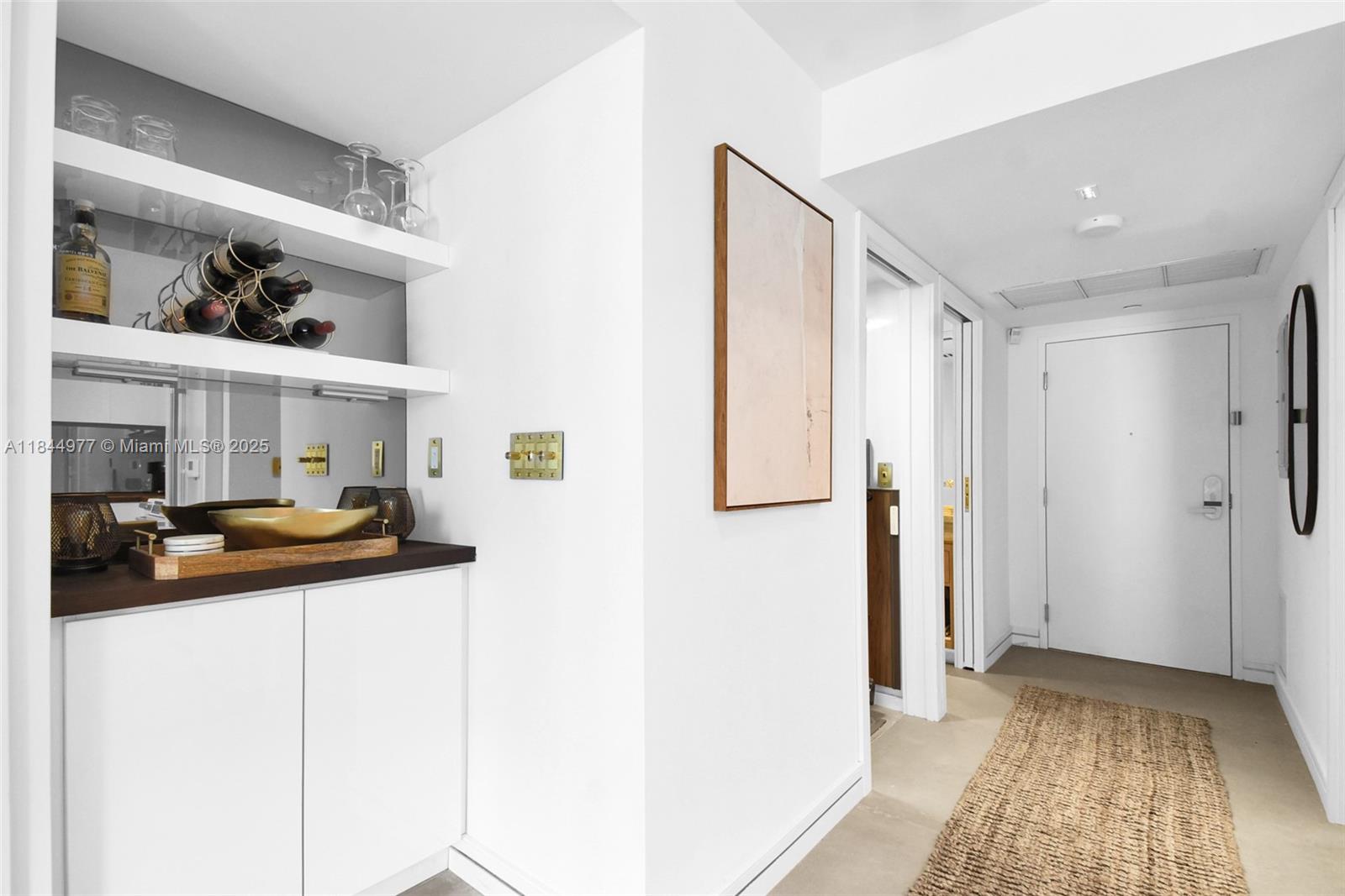2301 Collins Avenue, Unit 1201 Miami Beach, FL 33139 - Photo 8 of 53 a view of a hallway to a bedroom with wooden floor and furniture