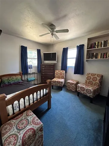 a bedroom with furniture and a large window