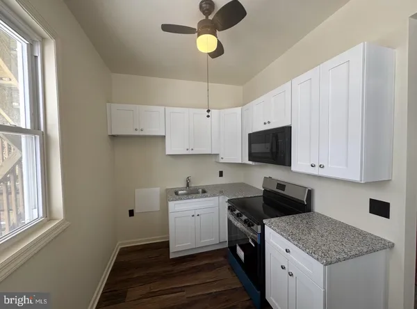 a kitchen with a stove sink and cabinets