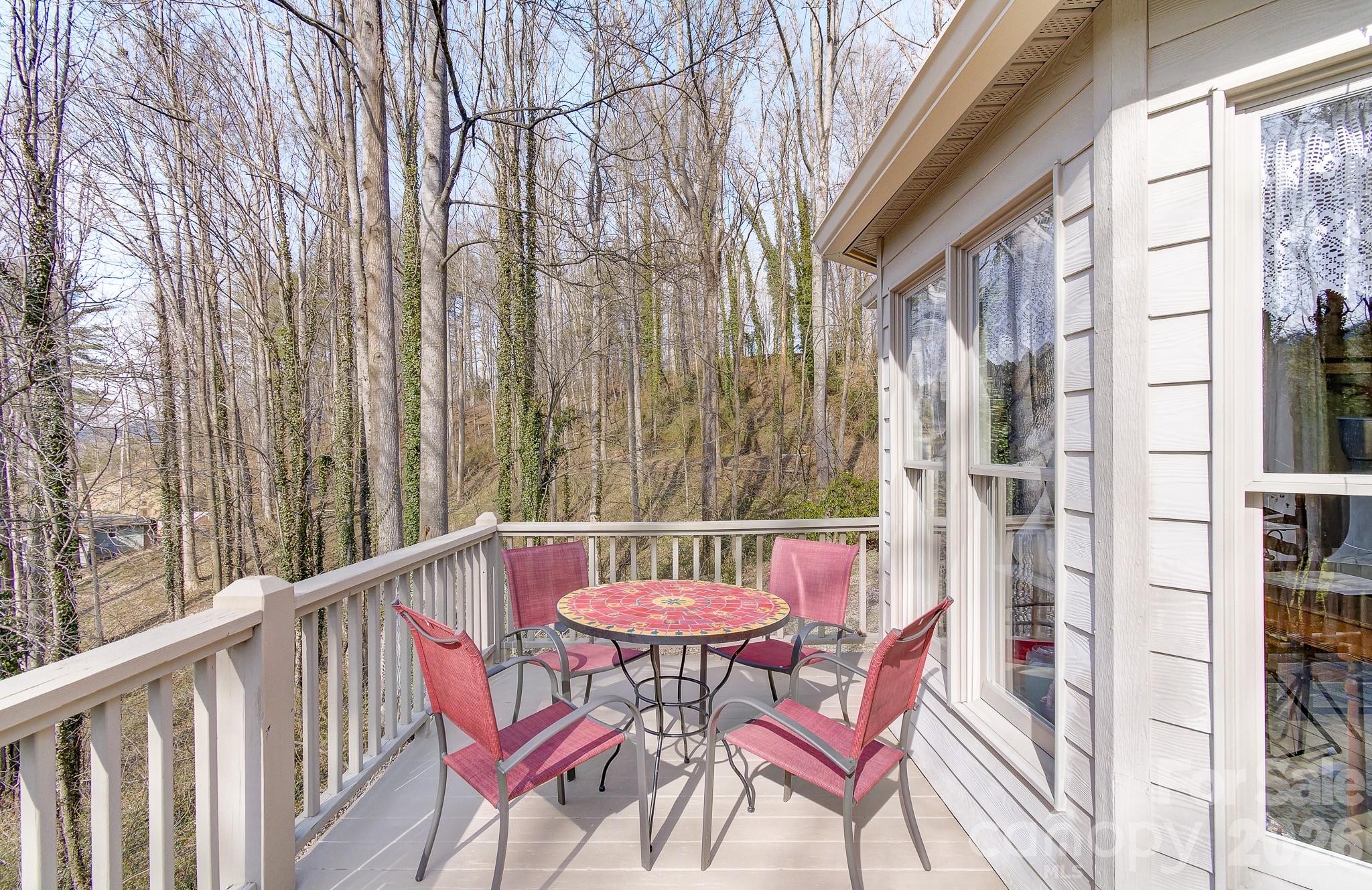 737 Woodbine Road Waynesville, NC 28785 - Photo 12 of 48 a view of a balcony with a table and chairs