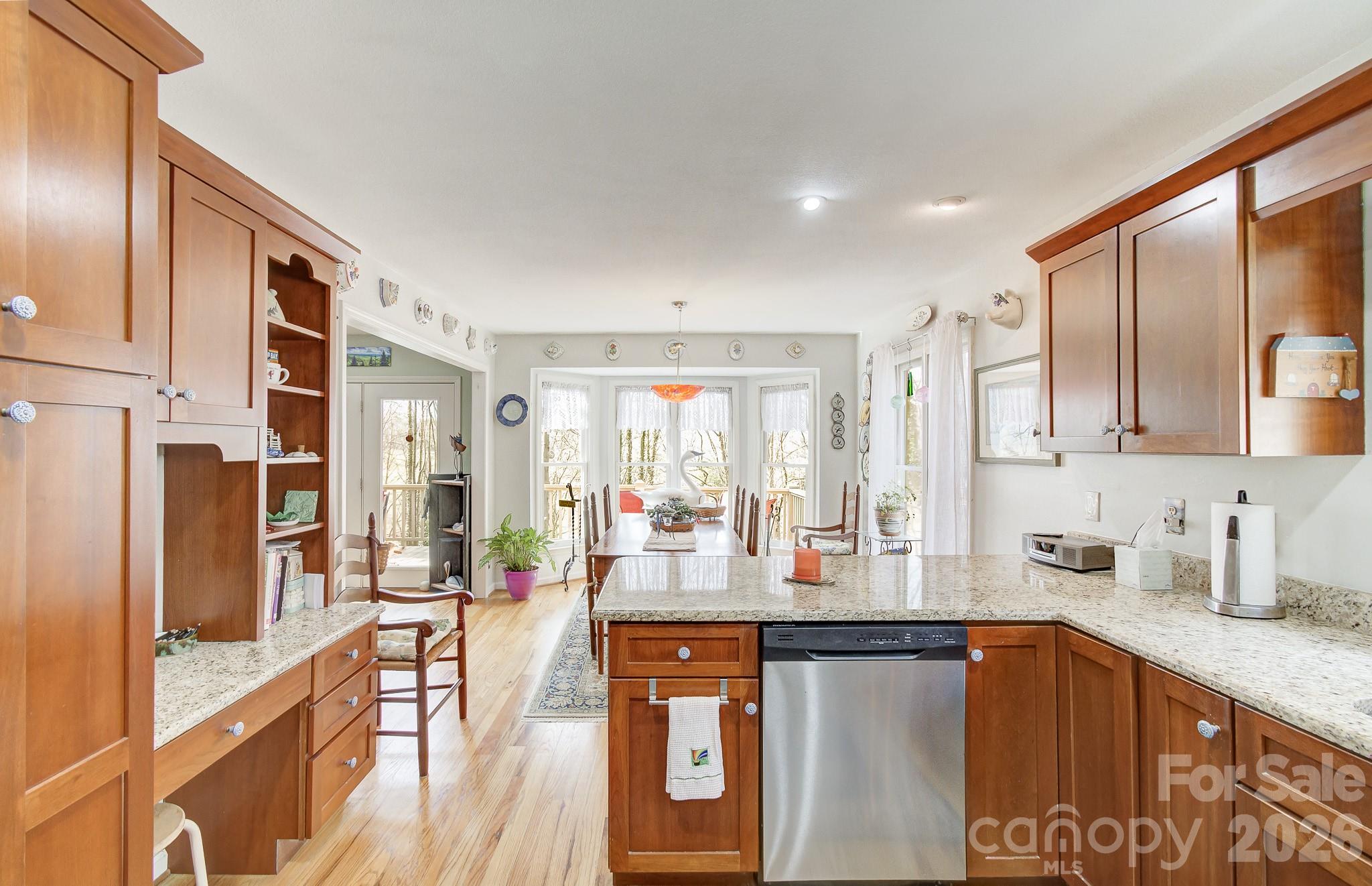 737 Woodbine Road Waynesville, NC 28785 - Photo 18 of 48 a kitchen with stainless steel appliances granite countertop a refrigerator a sink dishwasher a stove and white countertops with wooden floor