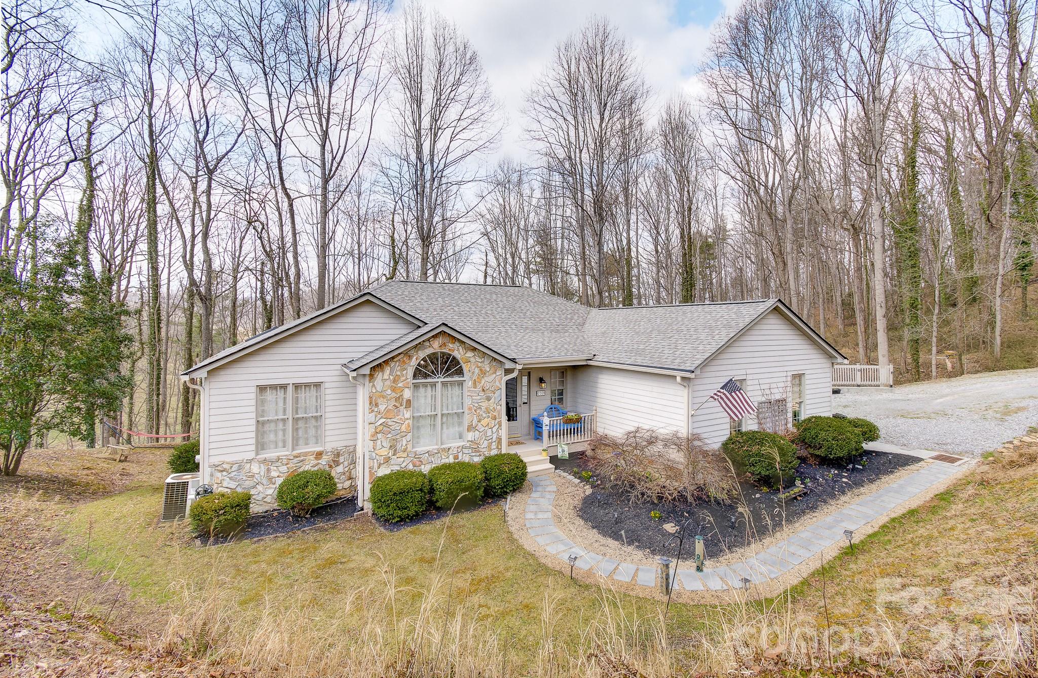737 Woodbine Road Waynesville, NC 28785 - Photo 48 of 48 a front view of a house with a yard and potted plants