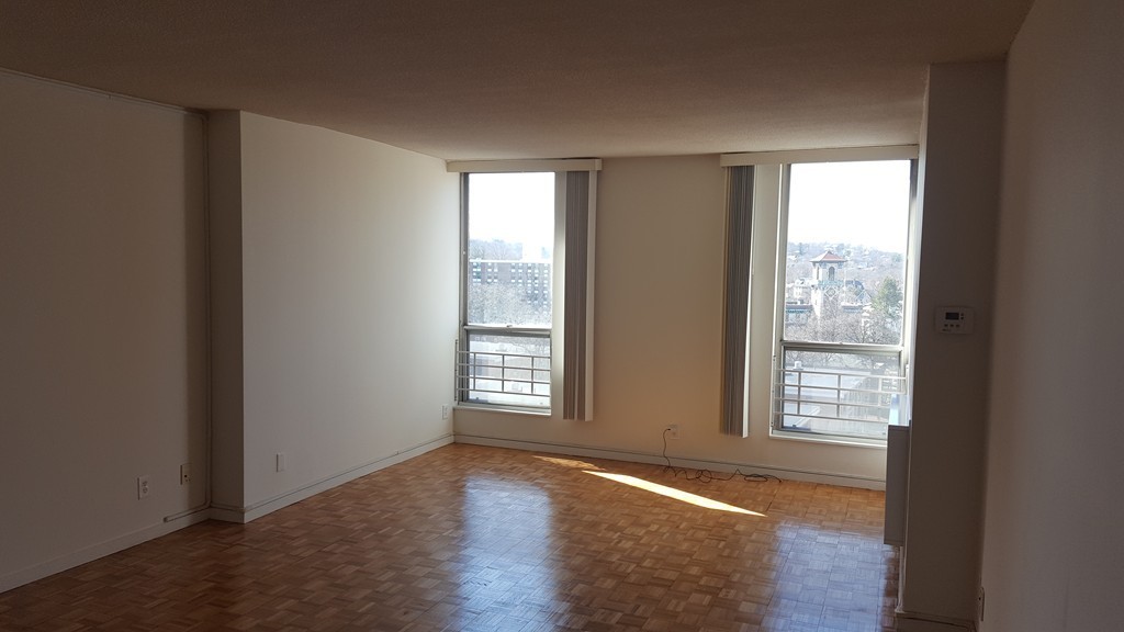 33 Pond Avenue, Unit 902 Brookline, MA 02445 - Photo 7 of 17 a view of an empty room with wooden floor and a window