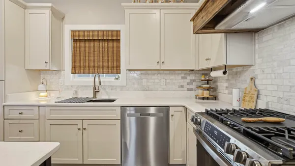 a kitchen with white cabinets and appliances