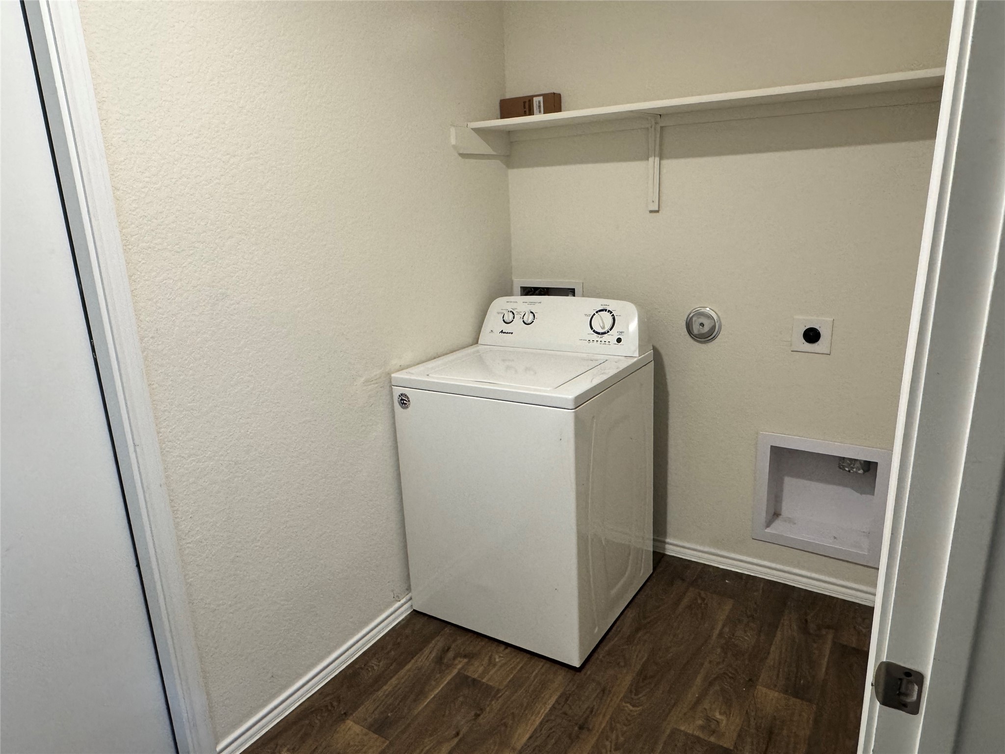 11820 Rush Lane Elgin, TX 78621 - Photo 9 of 31 A well-equipped laundry space with durable wood-look flooring and ample shelving.