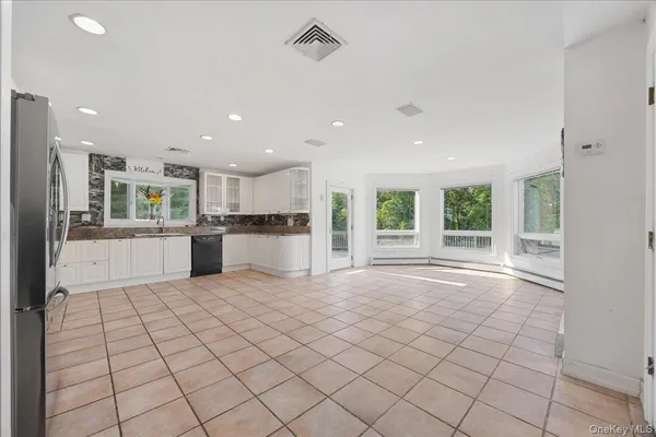a view of kitchen with granite countertop cabinets and refrigerator