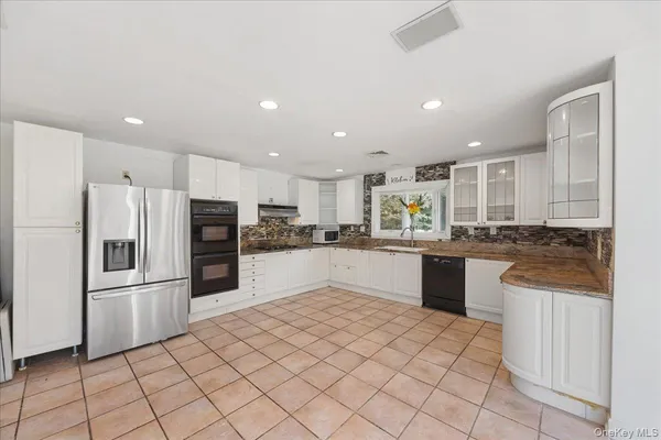 a kitchen with granite countertop a refrigerator and a sink