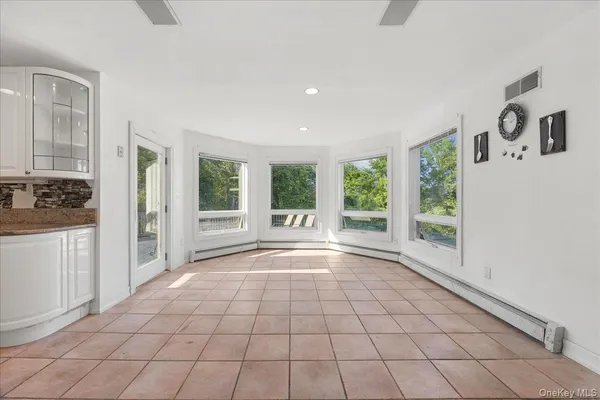 a view of an empty room with window and cabinet