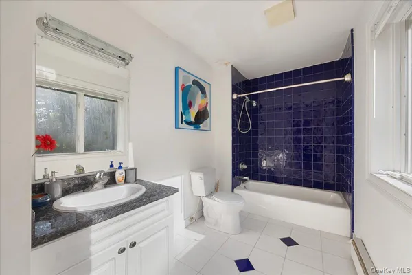 a bathroom with a granite countertop sink a mirror a bathtub and a shower