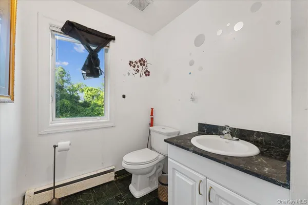 a bathroom with a granite countertop sink and a mirror