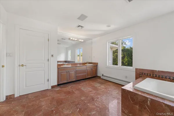 a bathroom with a tub sink and mirror