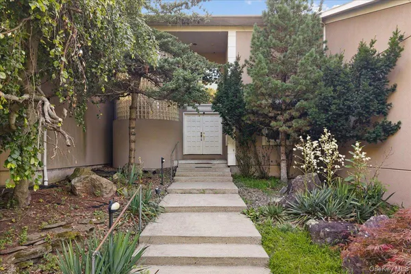 a front view of a house with a yard and fountain in middle