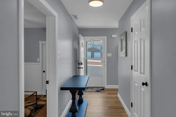 a view of a hallway with bathroom and wooden floor