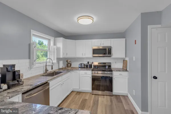a kitchen with a sink a stove a microwave and cabinets