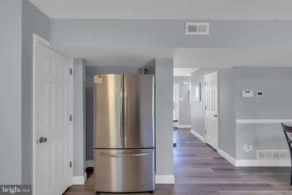 a view of a hallway with wooden floor and closet area