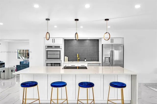 a kitchen with stainless steel appliances kitchen island granite countertop a table and chairs