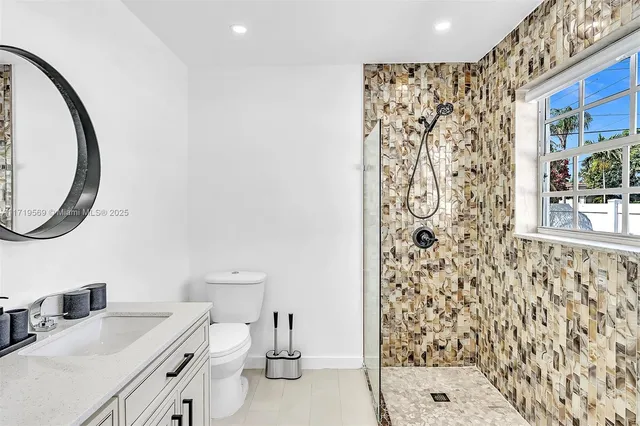 a bathroom with a toilet a sink and a mirror