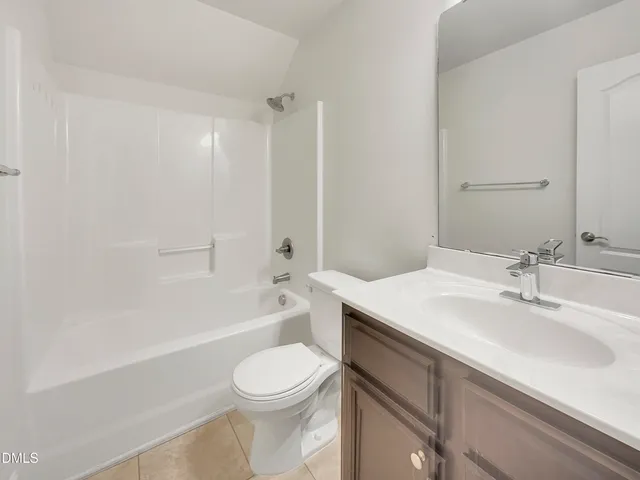 a bathroom with a sink a toilet a mirror and bathtub