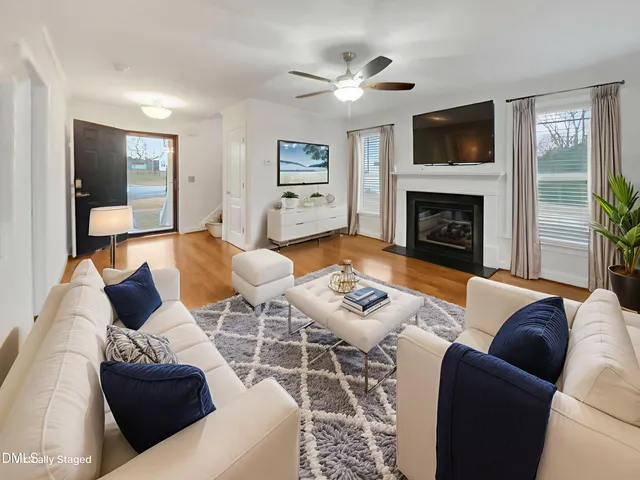 a living room with furniture a flat screen tv and a fireplace