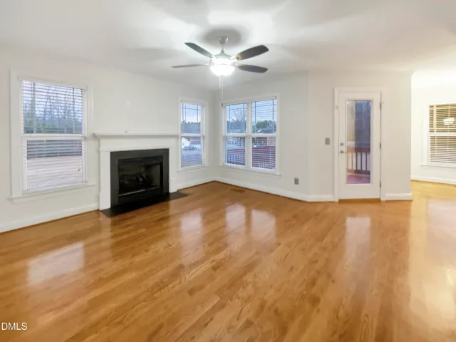 an empty room with windows and fireplace