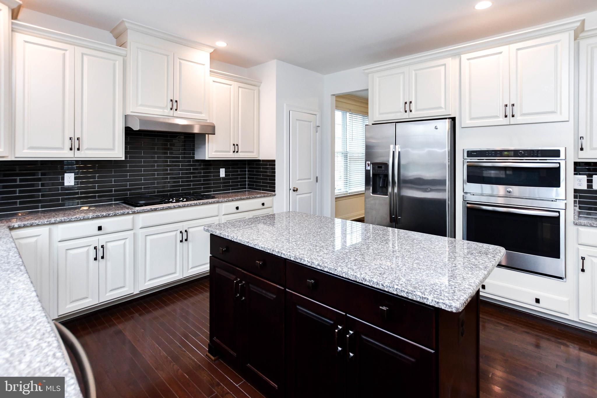 1610 Stream Valley Overlook Severn, MD 21144 - Photo 14 of 86 a kitchen with a sink a microwave a refrigerator and cabinets