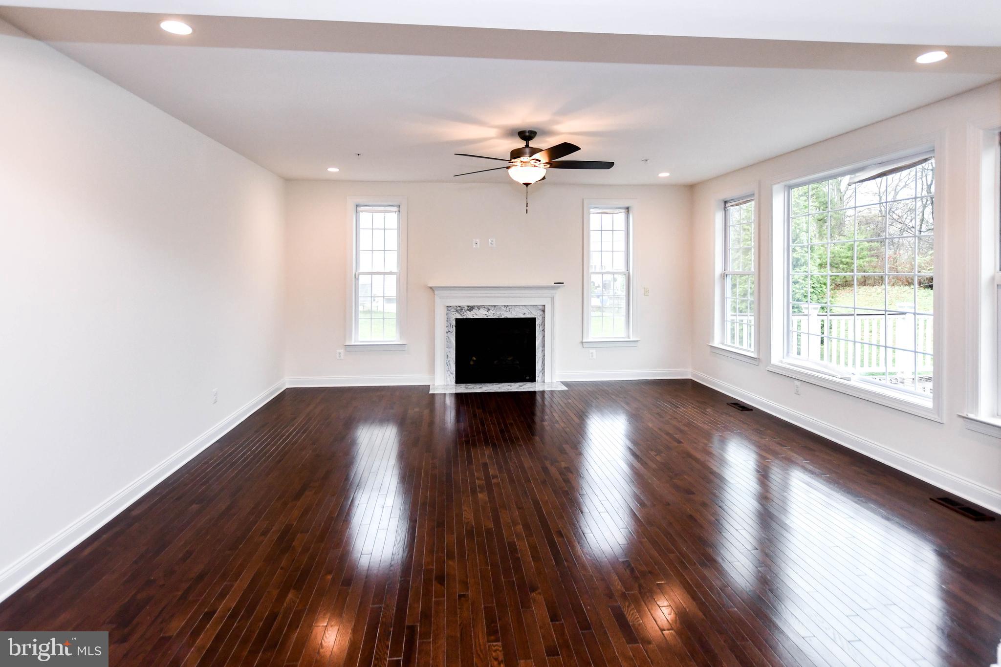 1610 Stream Valley Overlook Severn, MD 21144 - Photo 24 of 86 a view of a livingroom with wooden floor fireplace and a window