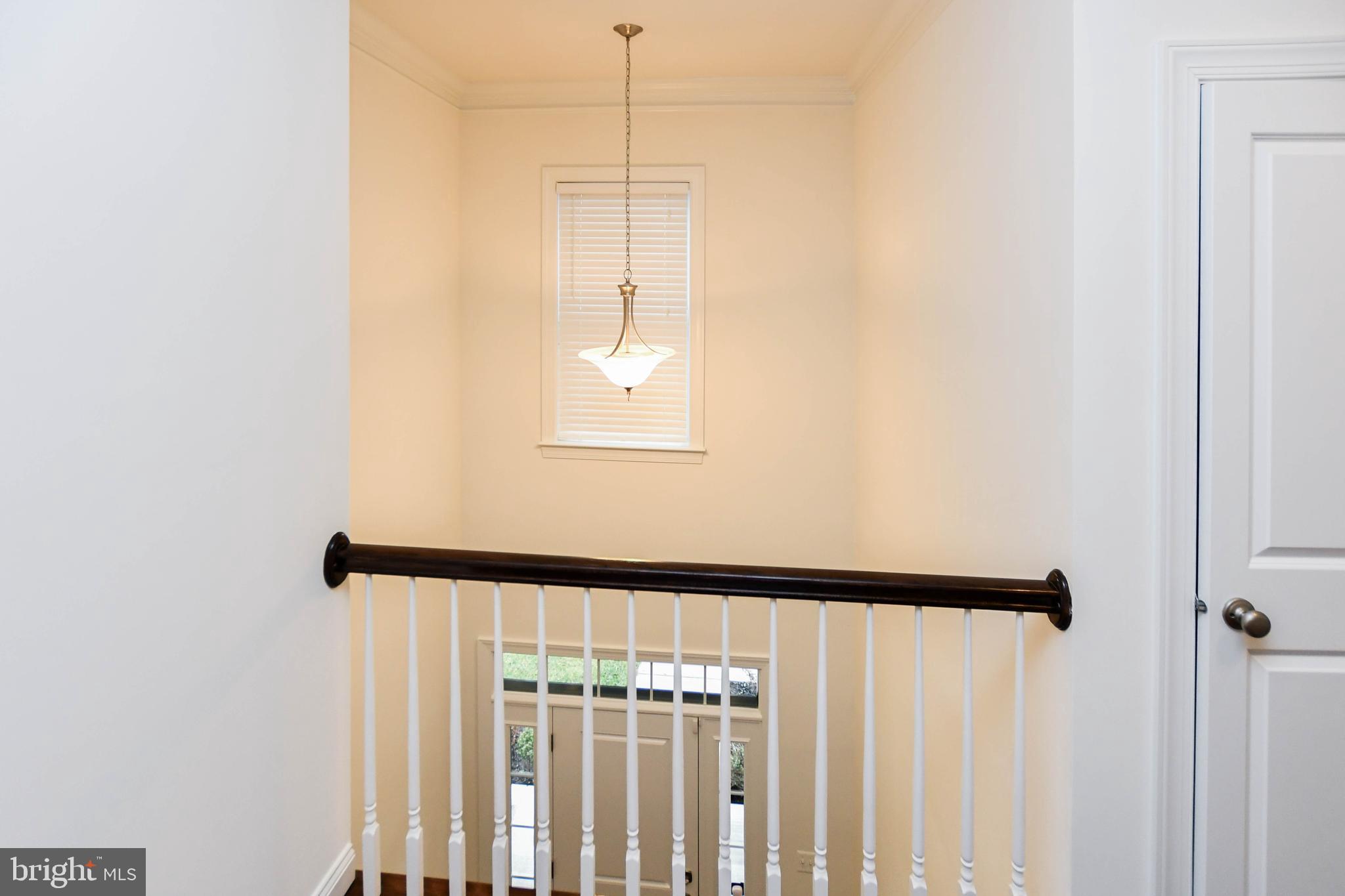 1610 Stream Valley Overlook Severn, MD 21144 - Photo 32 of 86 a view of a hallway with wooden floor and staircase