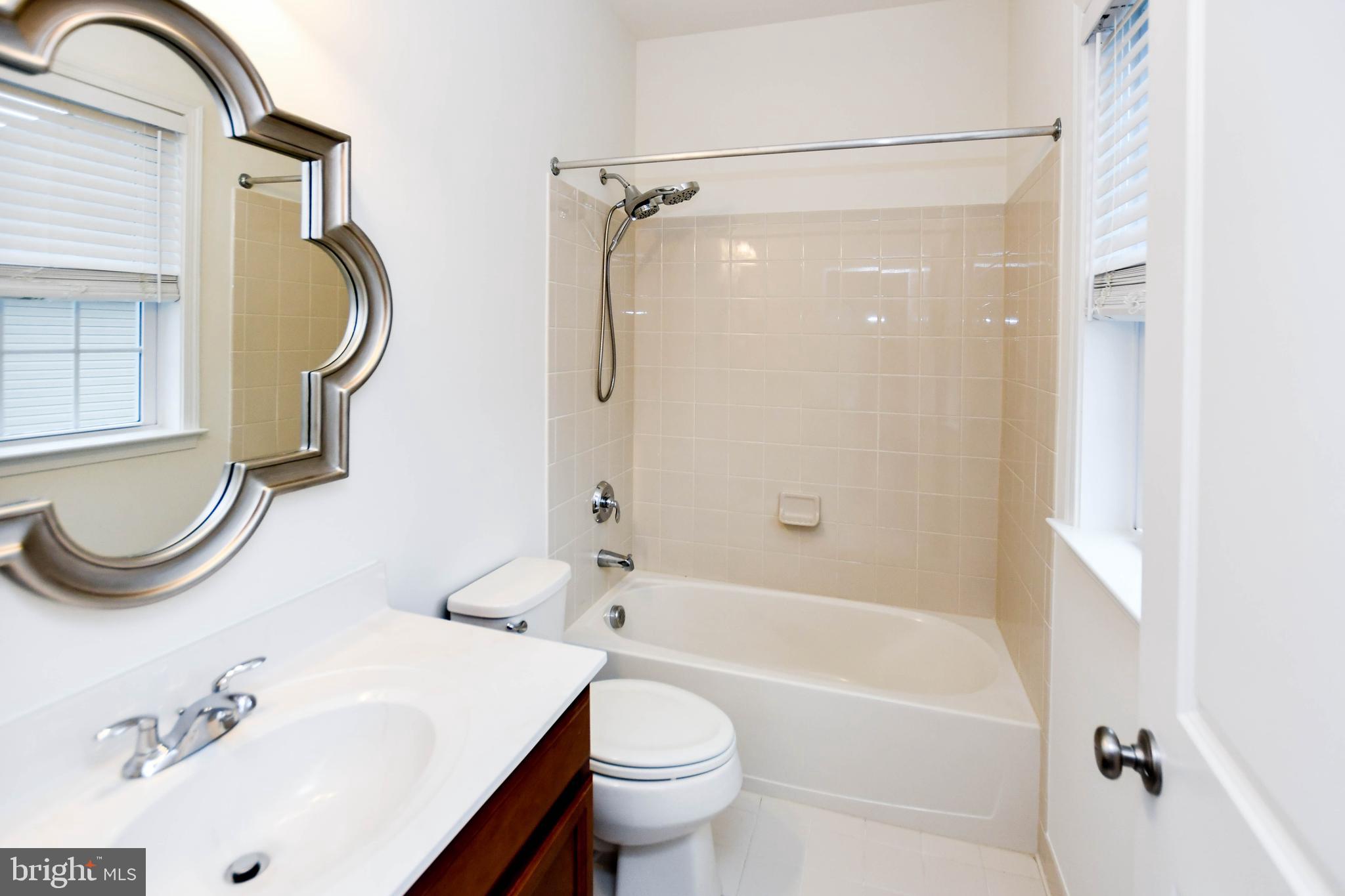 1610 Stream Valley Overlook Severn, MD 21144 - Photo 34 of 86 a bathroom with a sink a toilet and a mirror