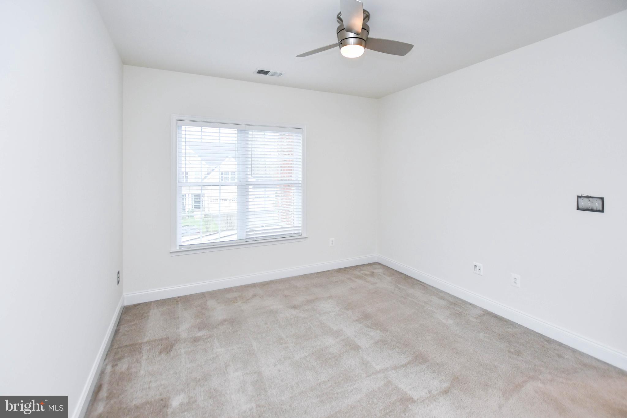 1610 Stream Valley Overlook Severn, MD 21144 - Photo 35 of 86 an empty room with a window and ceiling fan