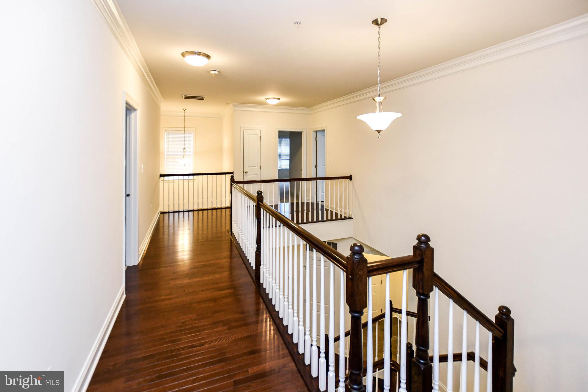 1610 Stream Valley Overlook Severn, MD 21144 - Photo 45 of 86 a view of a hallway with wooden floor and staircase