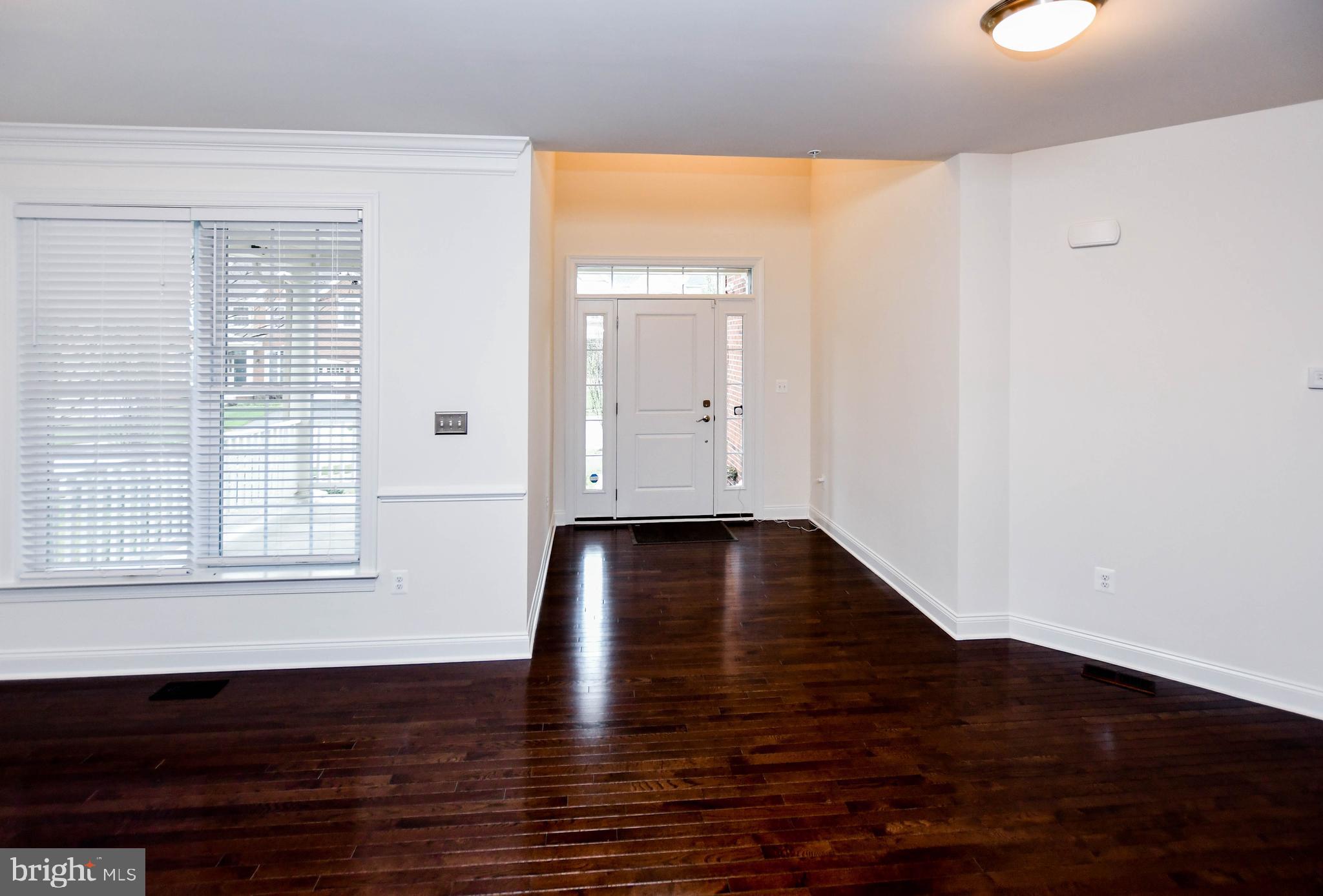 1610 Stream Valley Overlook Severn, MD 21144 - Photo 10 of 86 a view of an empty room with wooden floor and a window