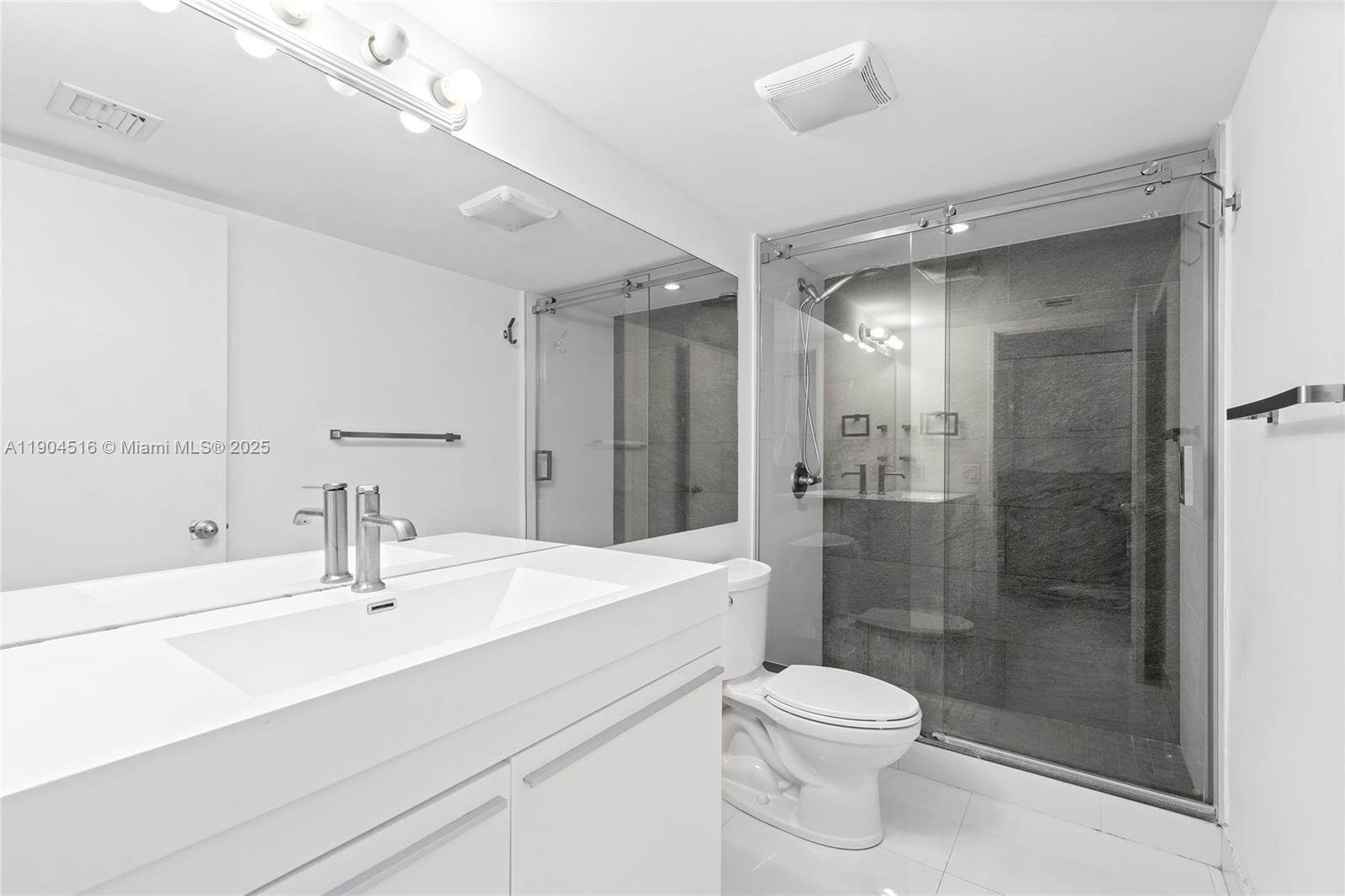 161 Crandon Boulevard, Unit 419 Key Biscayne, FL 33149 - Photo 13 of 35 a bathroom with a sink a toilet and shower