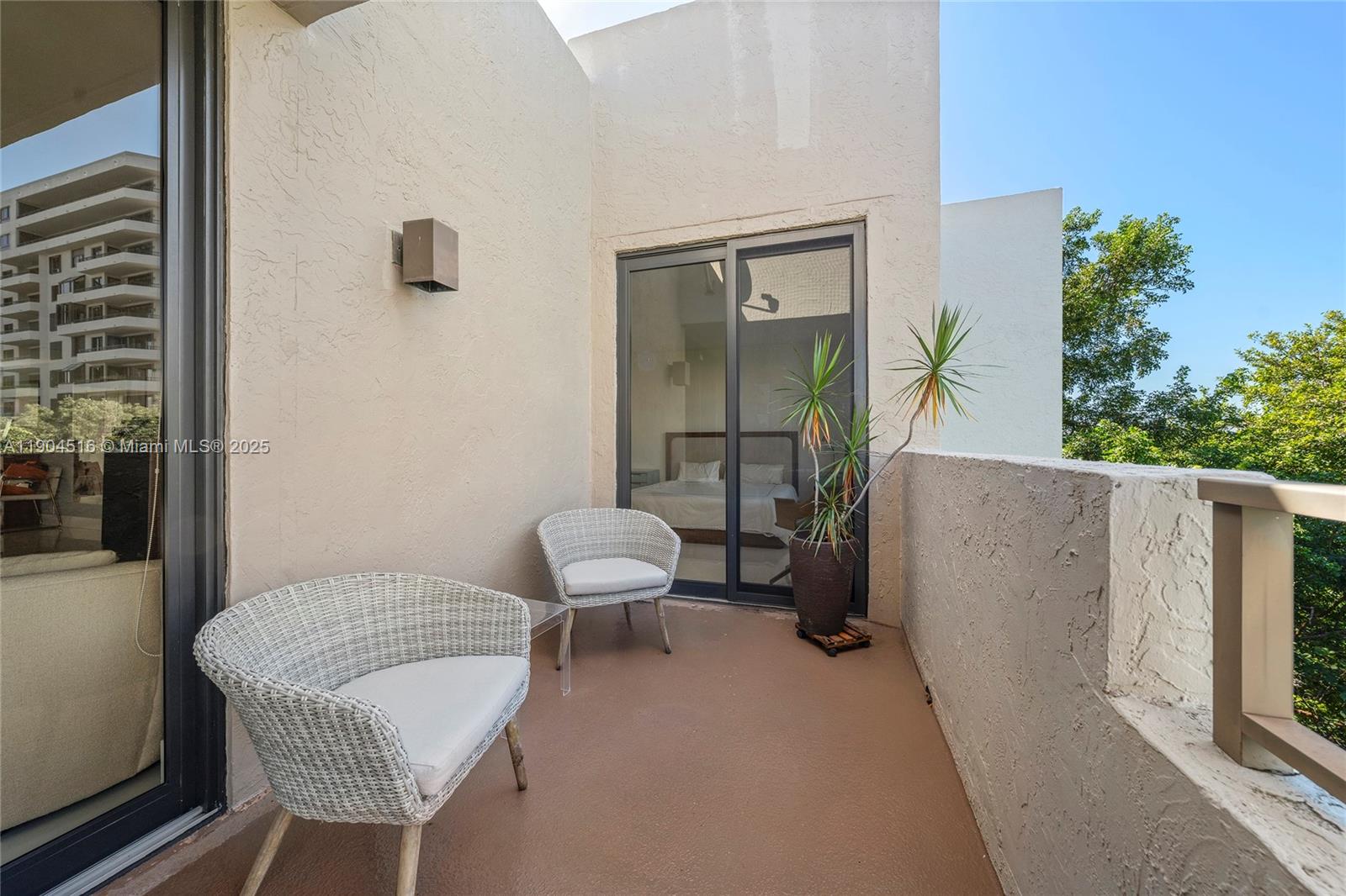 161 Crandon Boulevard, Unit 419 Key Biscayne, FL 33149 - Photo 16 of 35 a balcony with a table and chairs