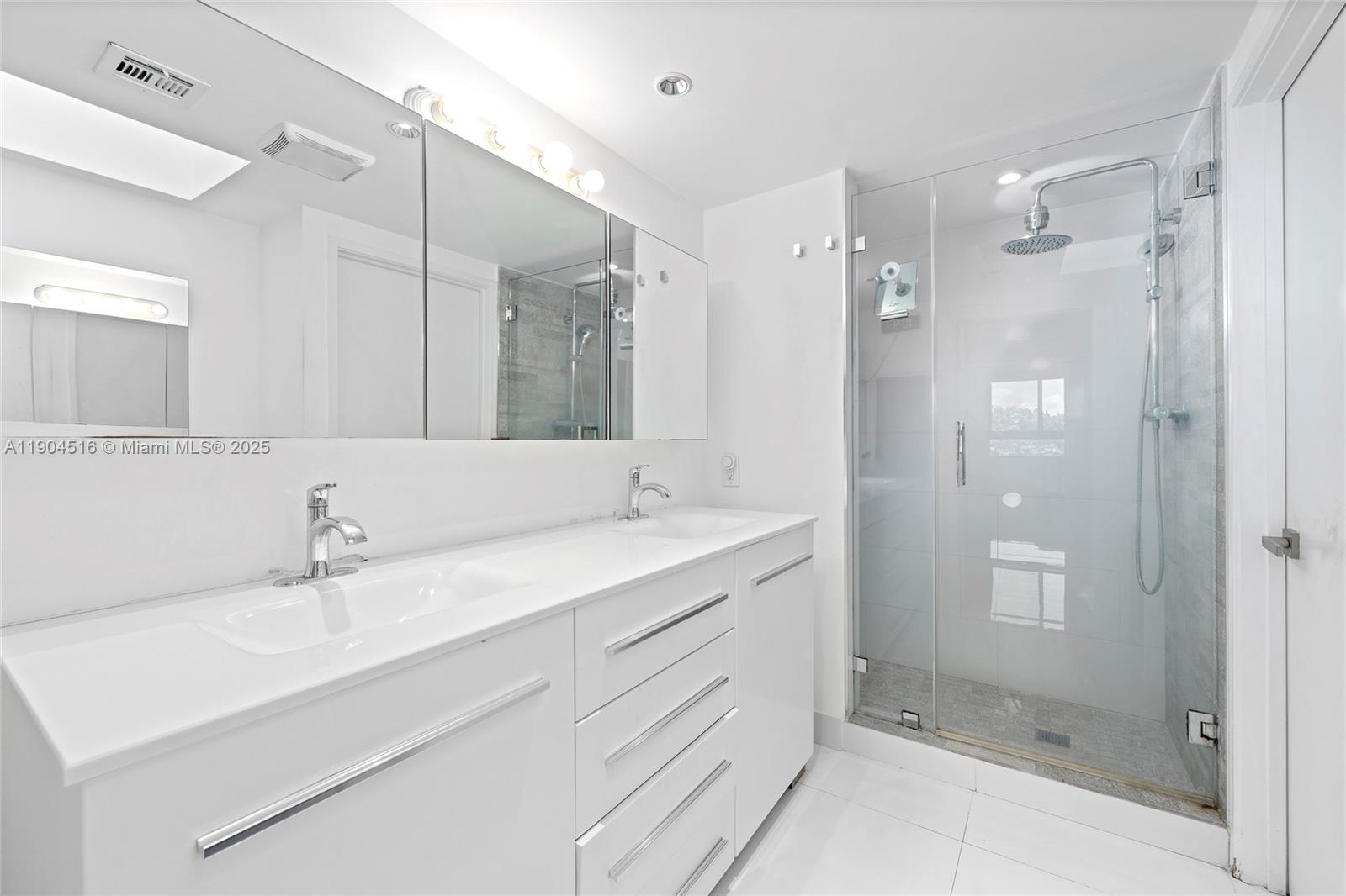161 Crandon Boulevard, Unit 419 Key Biscayne, FL 33149 - Photo 10 of 35 a bathroom with a shower sink and mirror