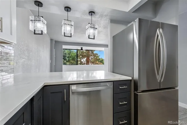 a kitchen with stainless steel appliances granite countertop a refrigerator and a sink