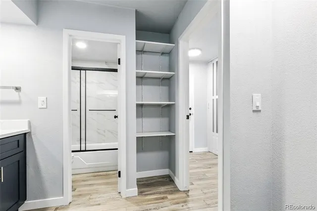 a bathroom with a walk in closet and mirror