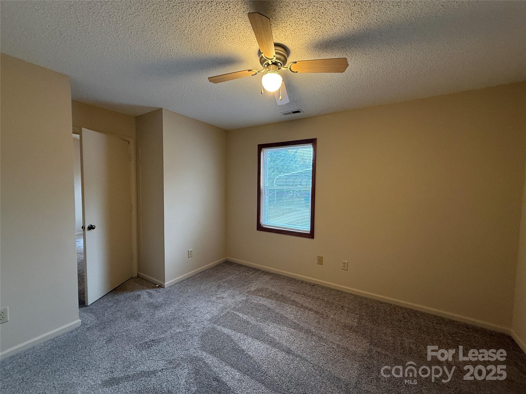 131 Pine Meadow Lane Mooresville, NC 28117 - Photo 11 of 20 an empty room with a ceiling fan and a window