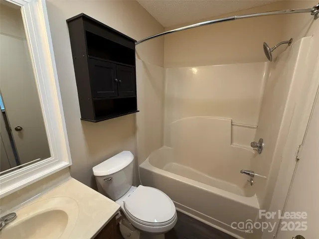 a white toilet sitting next to a bath tub