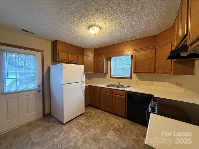 a kitchen with stainless steel appliances granite countertop a refrigerator sink and cabinets