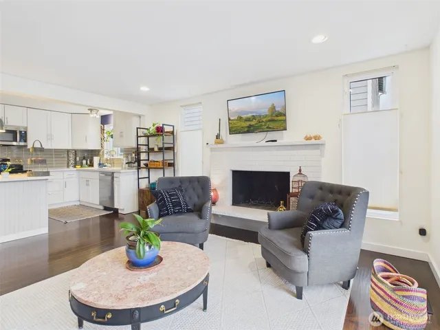 a kitchen with stainless steel appliances a refrigerator a sink dishwasher a stove and white cabinets with wooden floor