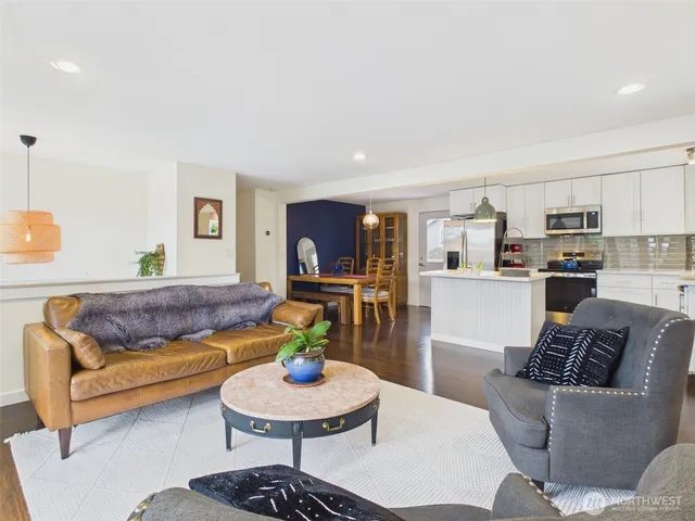 a kitchen with granite countertop a sink stainless steel appliances and white cabinets