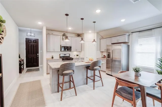 a kitchen with stainless steel appliances kitchen island granite countertop a refrigerator and a stove top oven