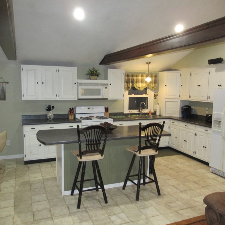 19 Haskell Road Pepperell, MA 01463 - Photo 12 of 40 a kitchen with stainless steel appliances granite countertop a stove a sink a microwave and a refrigerator